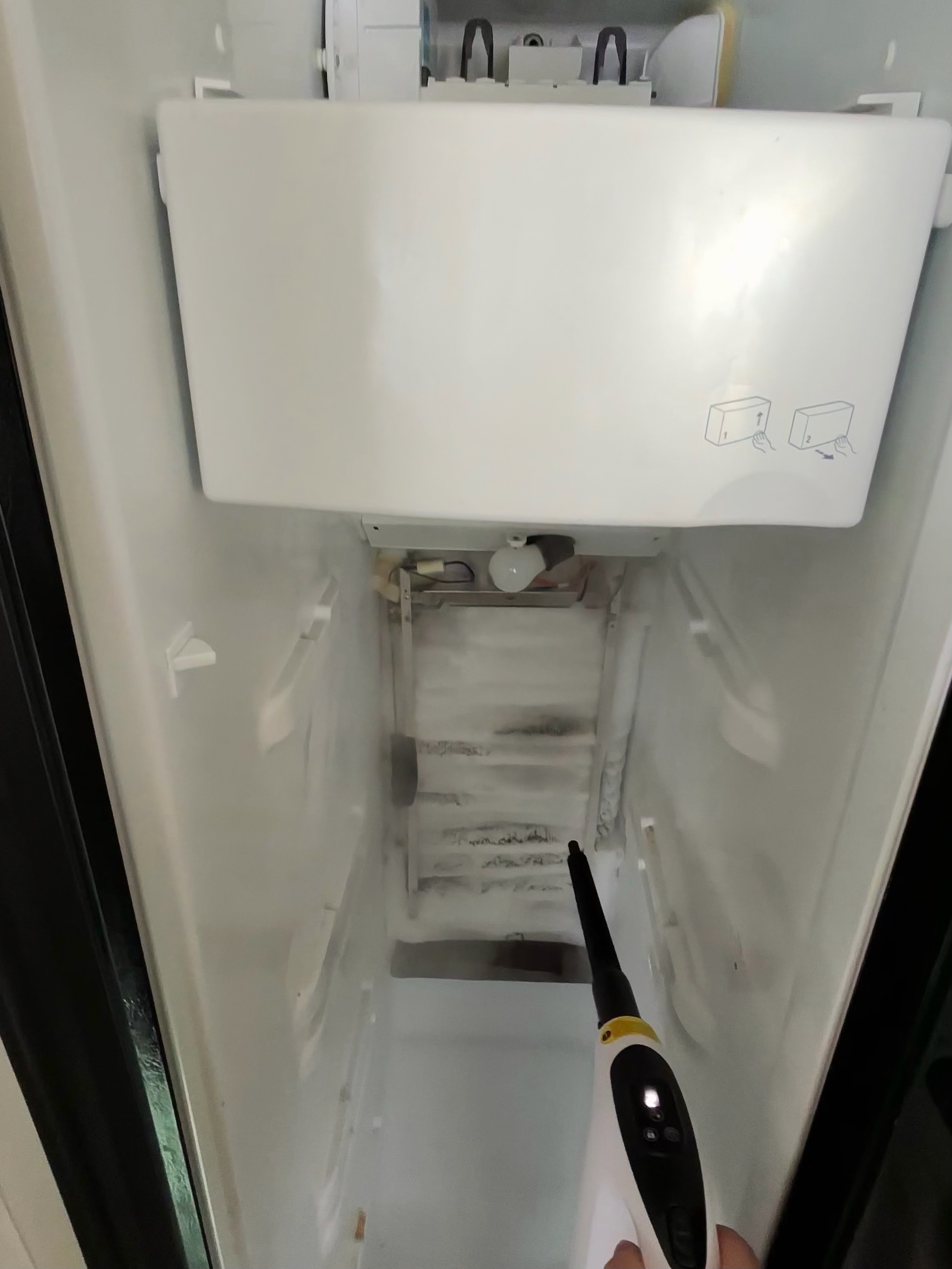 Freezer compartment being cleaned after defrost service and refrigerator repair